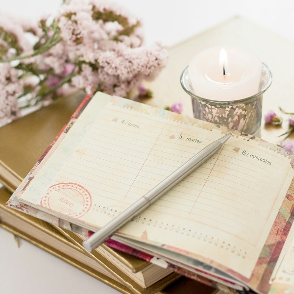 des carnets à remplir avec une bougie et des fleurs